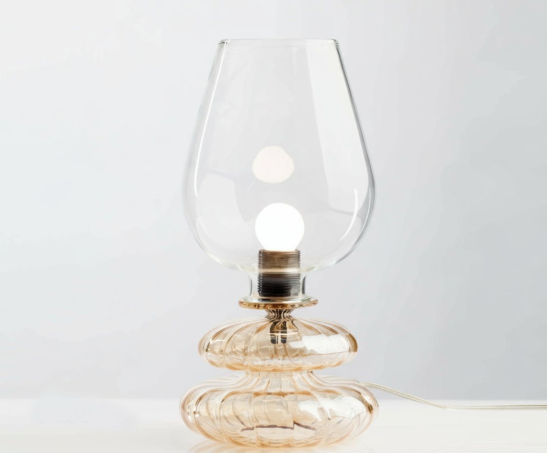 Glass table lamp with a clear glass shade on a white background