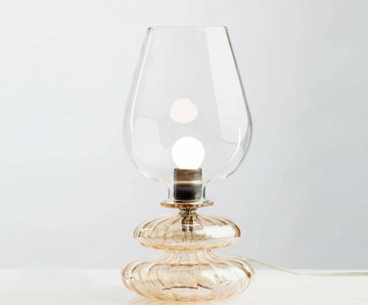 Glass table lamp with a clear glass shade on a white background
