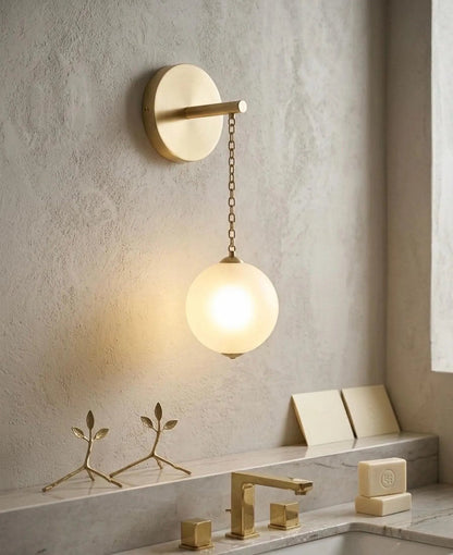 Modern bathroom light fixture with a round glass shade in a neutral-toned bathroom.