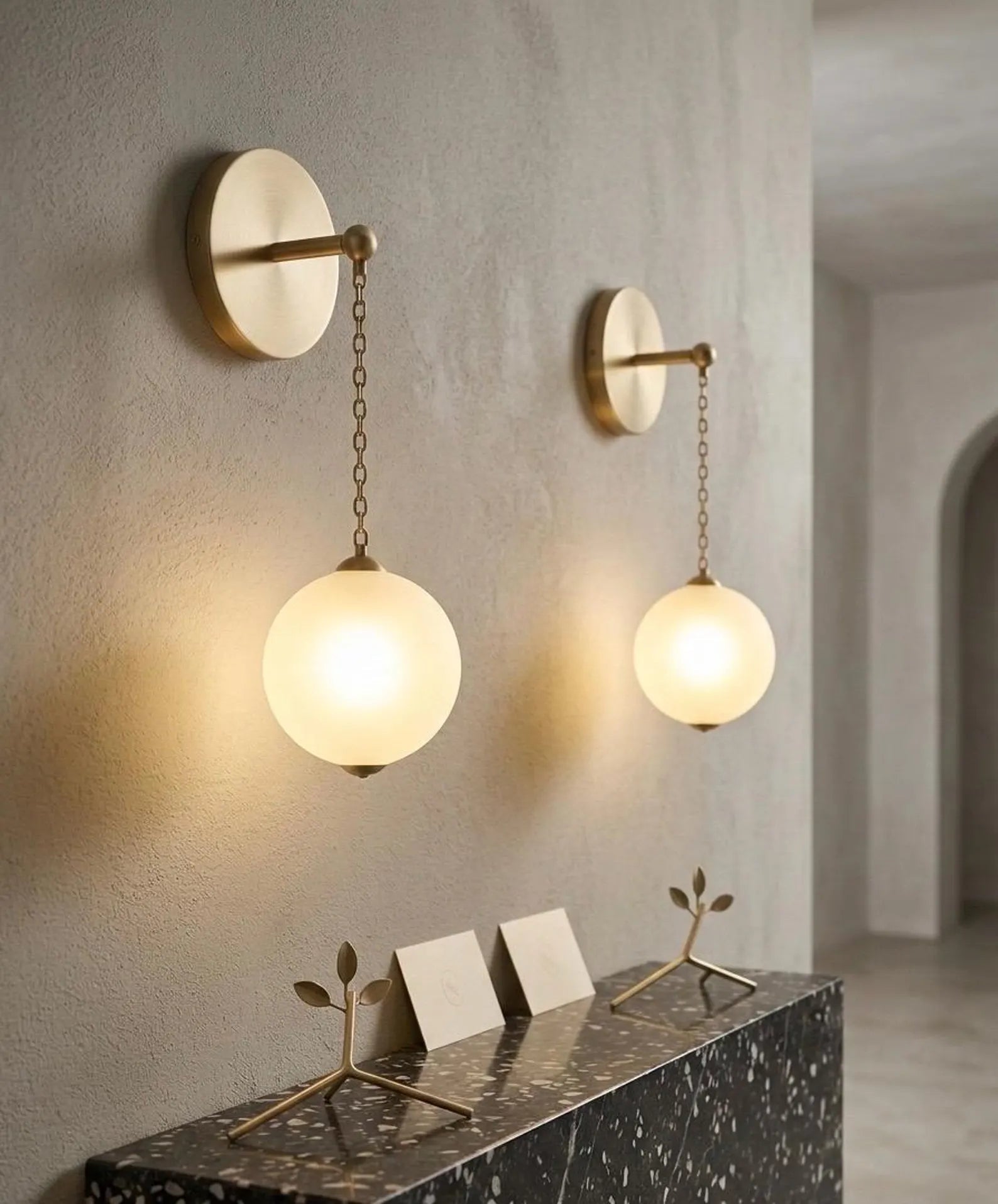 Two wall-mounted lights with glass globes on a neutral wall.