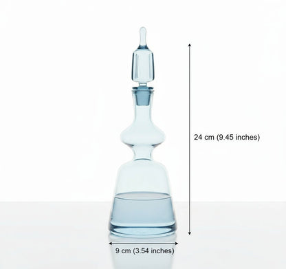 Clear glass decanter with wine glasses on a wooden table with a decorative background