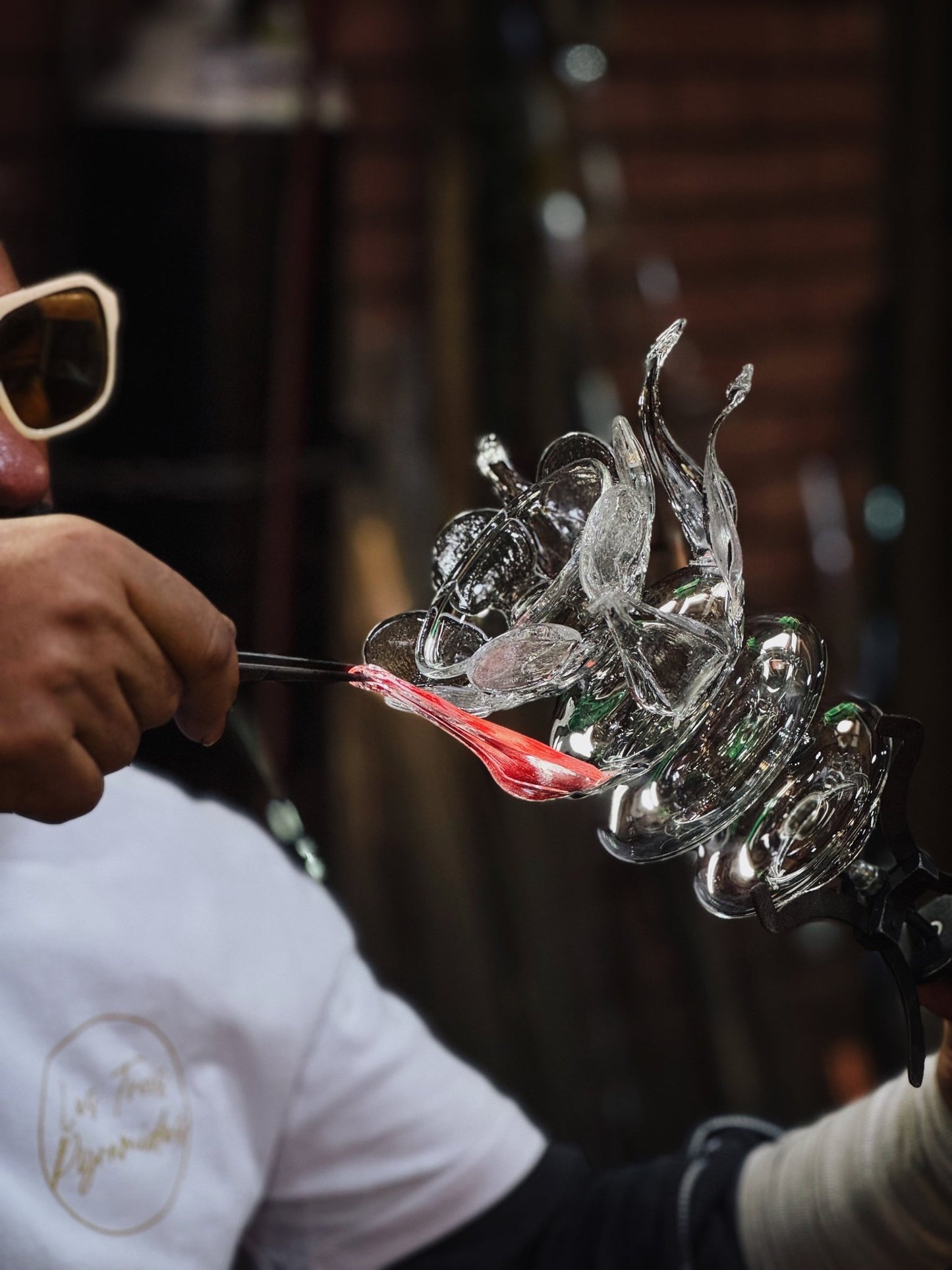 Hand shaping clear glass flower form for upside down bloom wall light