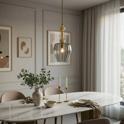 Decorative pendant light with glass shade and gold fixture in a room setting | Le Trois Pyramides