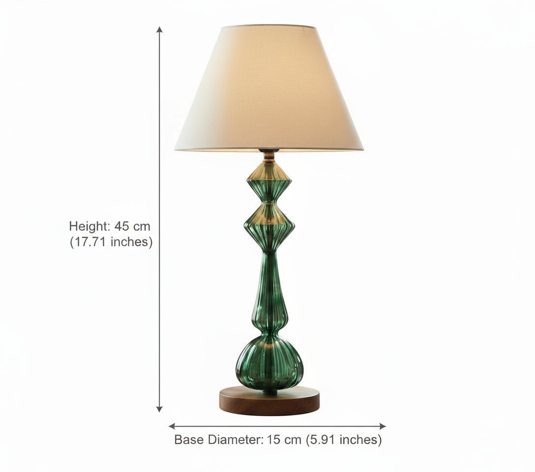 Decorative green lamp on a table with books, flowers, and a bird sculpture in a living room.