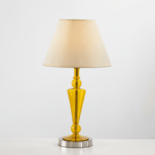 Table lamp with a yellow base and beige shade on a white background | Les Trois pyramides