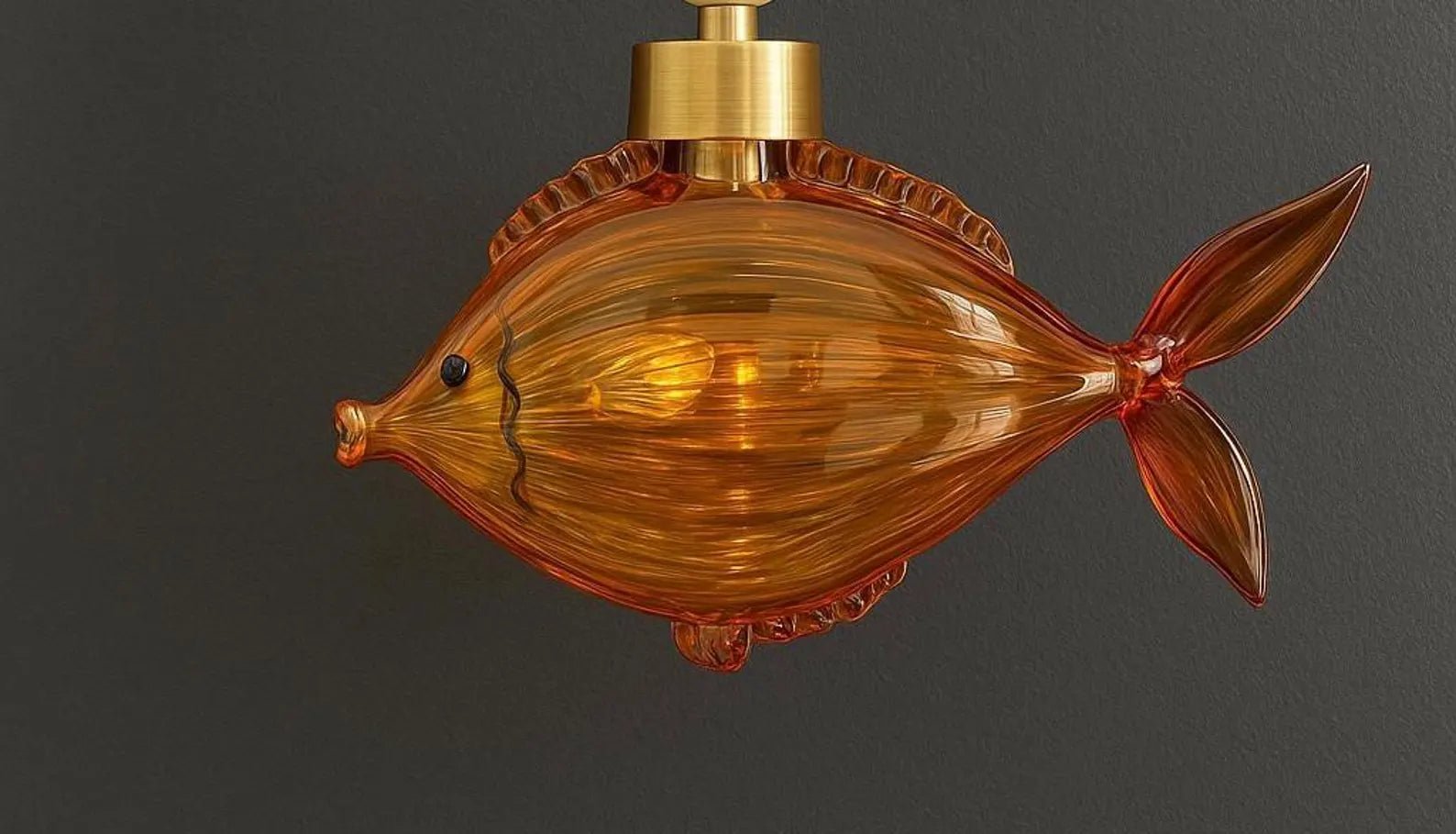 Fish-shaped amber glass light fixture on a dark background