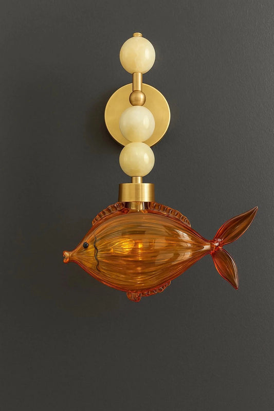 Decorative wall sconce with fish design on a dark background