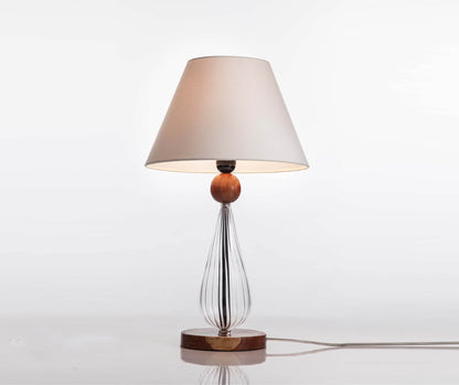 Table lamp with a wooden base and white shade on a light gray background