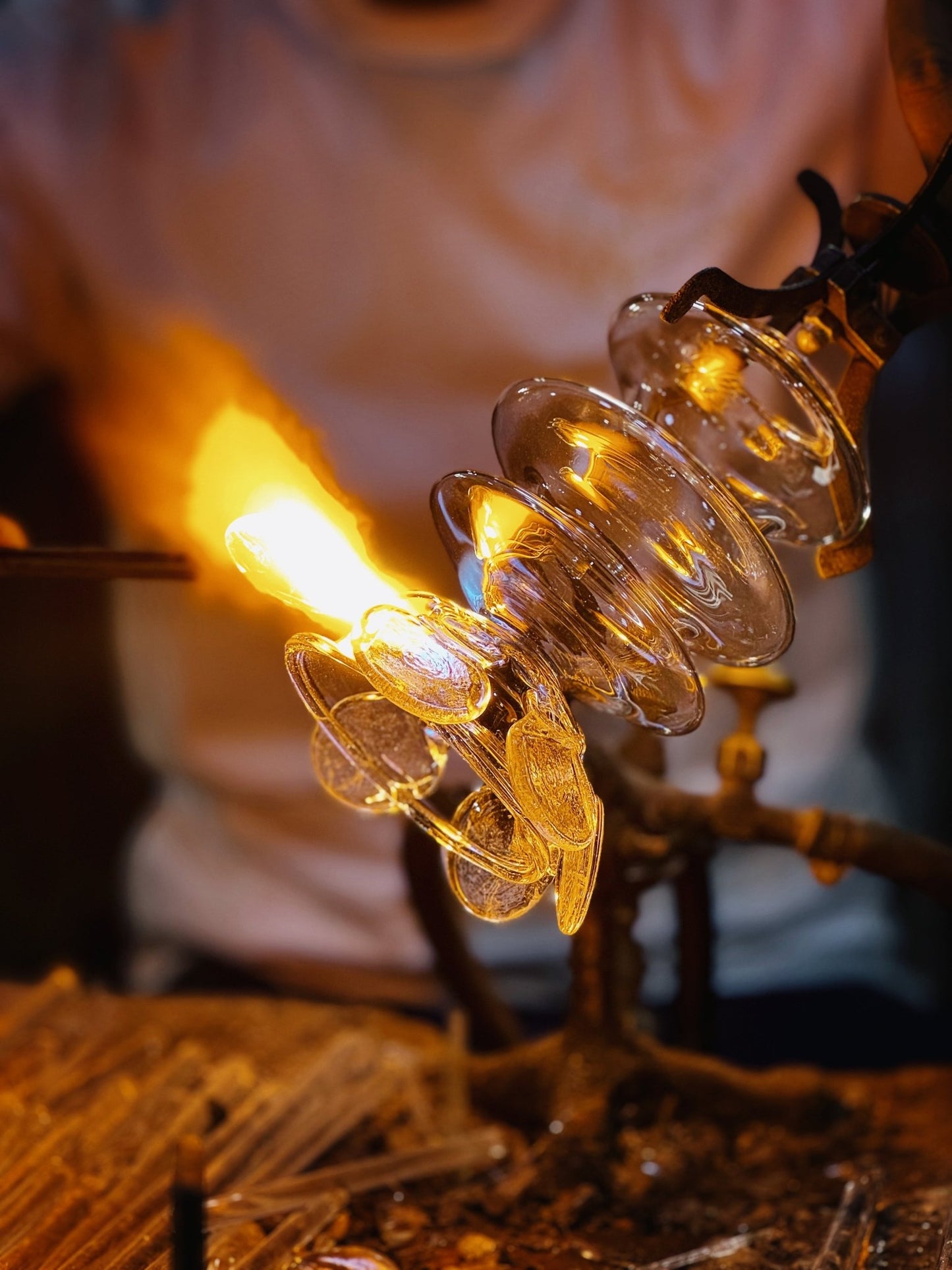 Molten glass being shaped by hand for upside down bloom wall sconce
