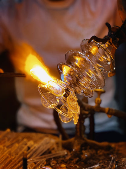 Molten glass being shaped by hand for upside down bloom wall sconce