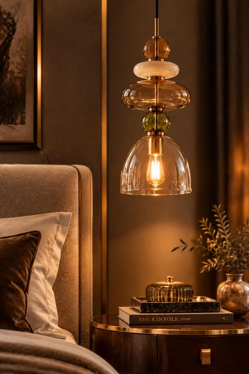 Handmade glass pendant light featuring amber, milky white, smoky grey and olive green glass elements, with brass accents and a clear champagne glass shade | Les Trois Pyramides