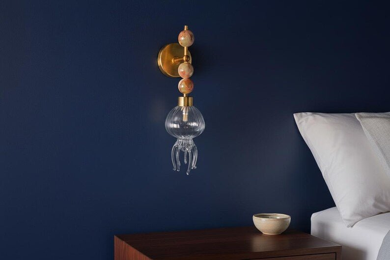 Ocean inspired jellyfish wall sconce in brass with hand blown glass