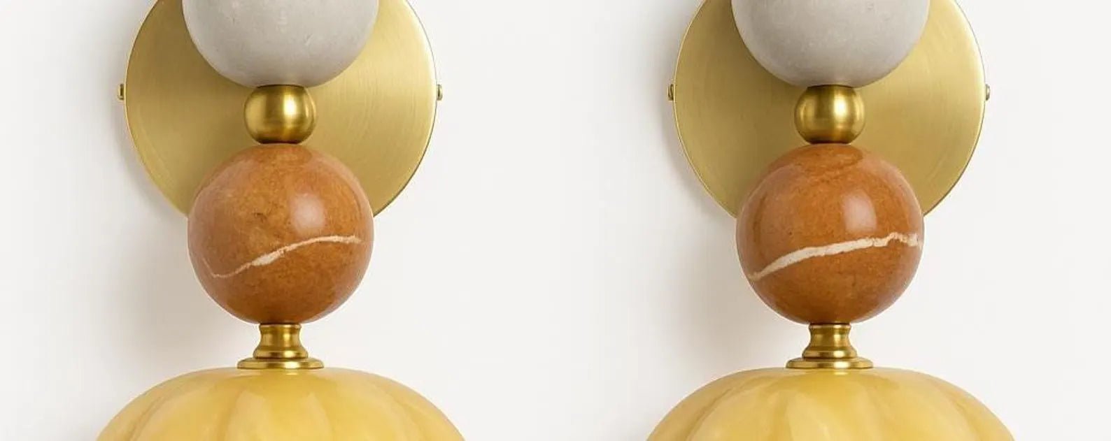 Two wall sconces with gold and marble design on a white background