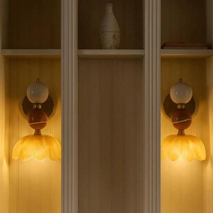Decorative wall sconces with floral designs on a wooden shelf.