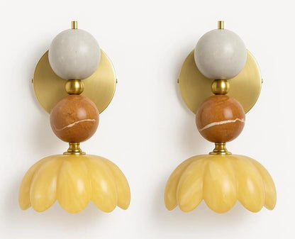 Pair of decorative wall sconces with marble and yellow design on a white background