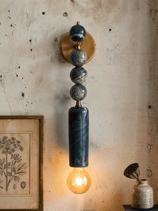 Wall-mounted lamp with marble-like design on a textured wall - Les Trois Pyramides