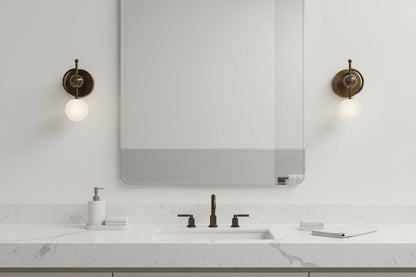 Marble wall sconces with frosted glass globes installed in bathroom lighting setup
