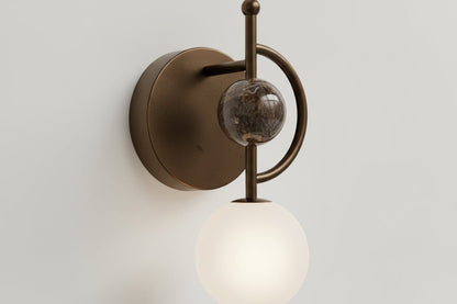 Handmade marble wall sconce with frosted glass globe and dark bronze metal finish
