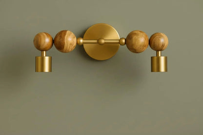Decorative wall light fixture with wooden and gold elements on a green background