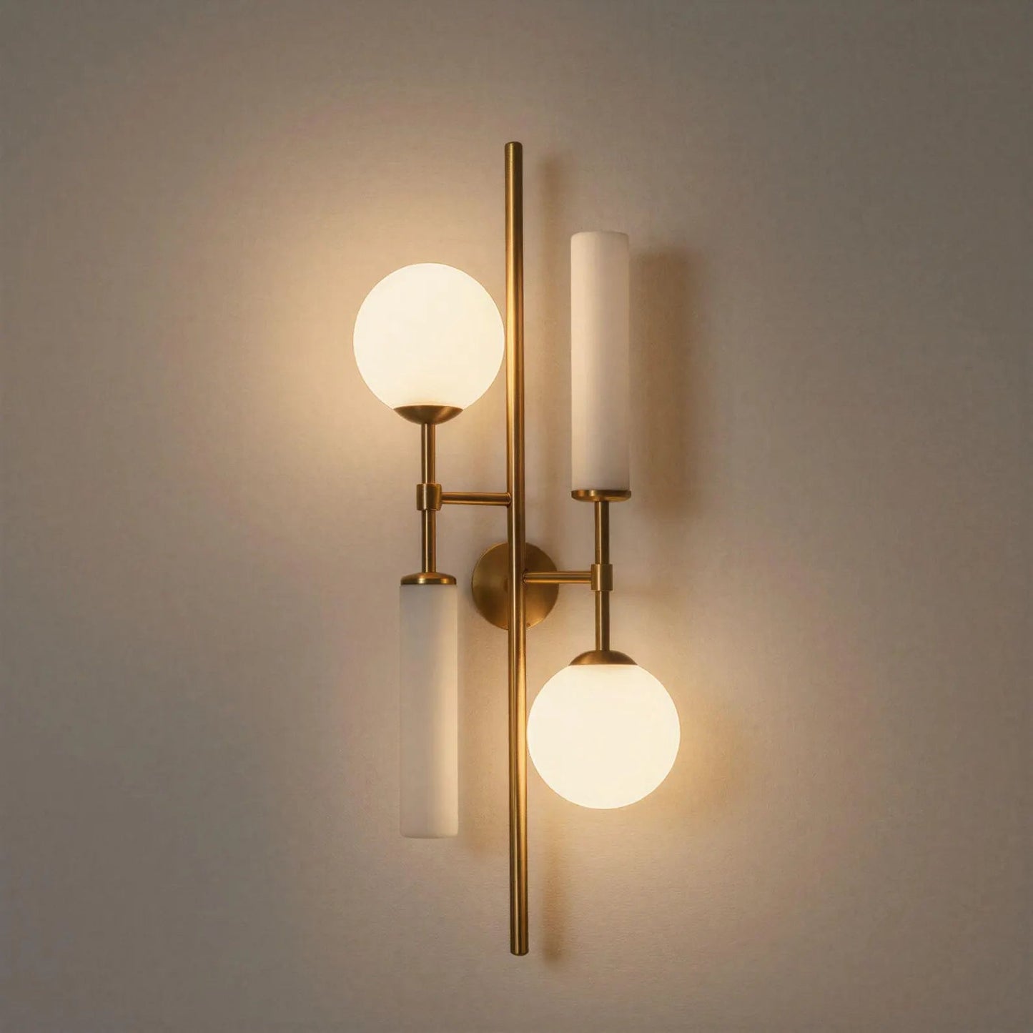 Modern wall sconce with gold fixture and glass globe lights on a neutral background