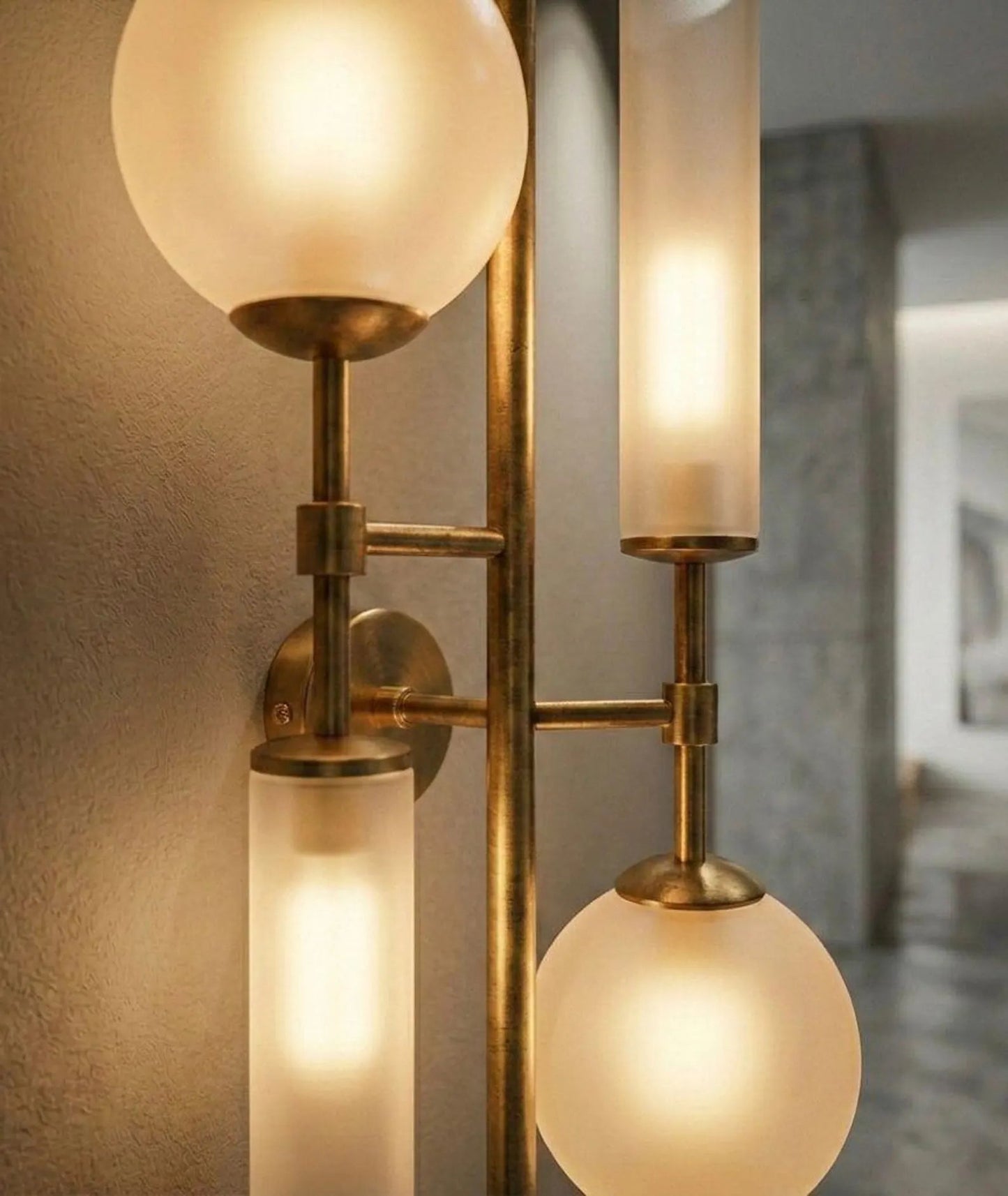 Wall-mounted light fixture with glass shades and brass accents.