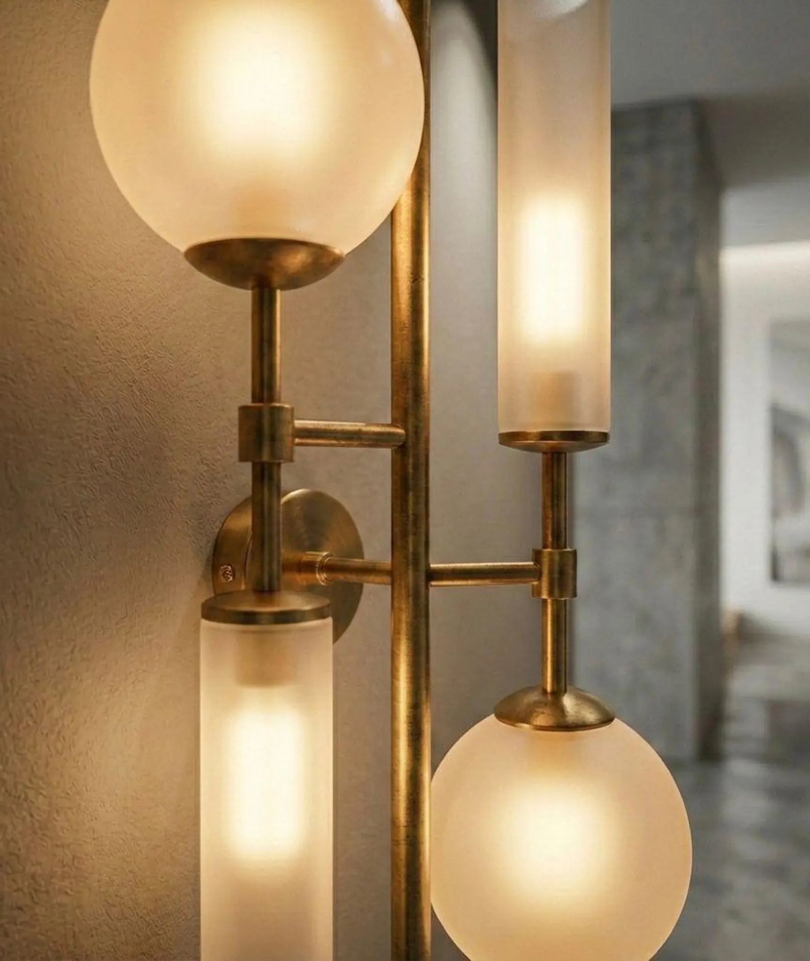 Wall-mounted light fixture with glass shades and brass accents.