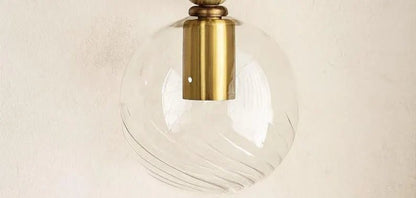 Pair of wall sconces with onyx, gold finish and glass globes on a neutral background | Les Trois Pyramides