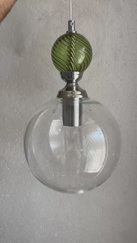 Modern pendant lights with glass shades and green accents hanging - Les Trois Pyramides