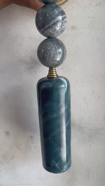 Wall-mounted lamp with marble-like design on a textured wall - Les Trois Pyramides