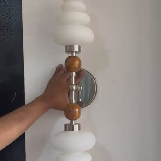 Double brass wall sconce with frosted glass shades and onyx stone details
