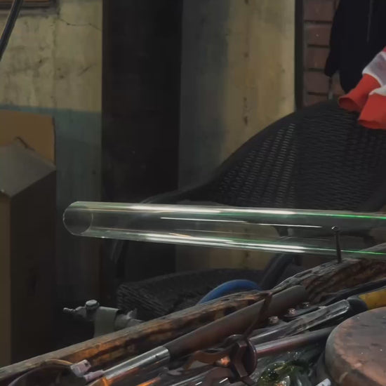 Glassblower shaping clear glass flower shade for upside down bloom wall sconce