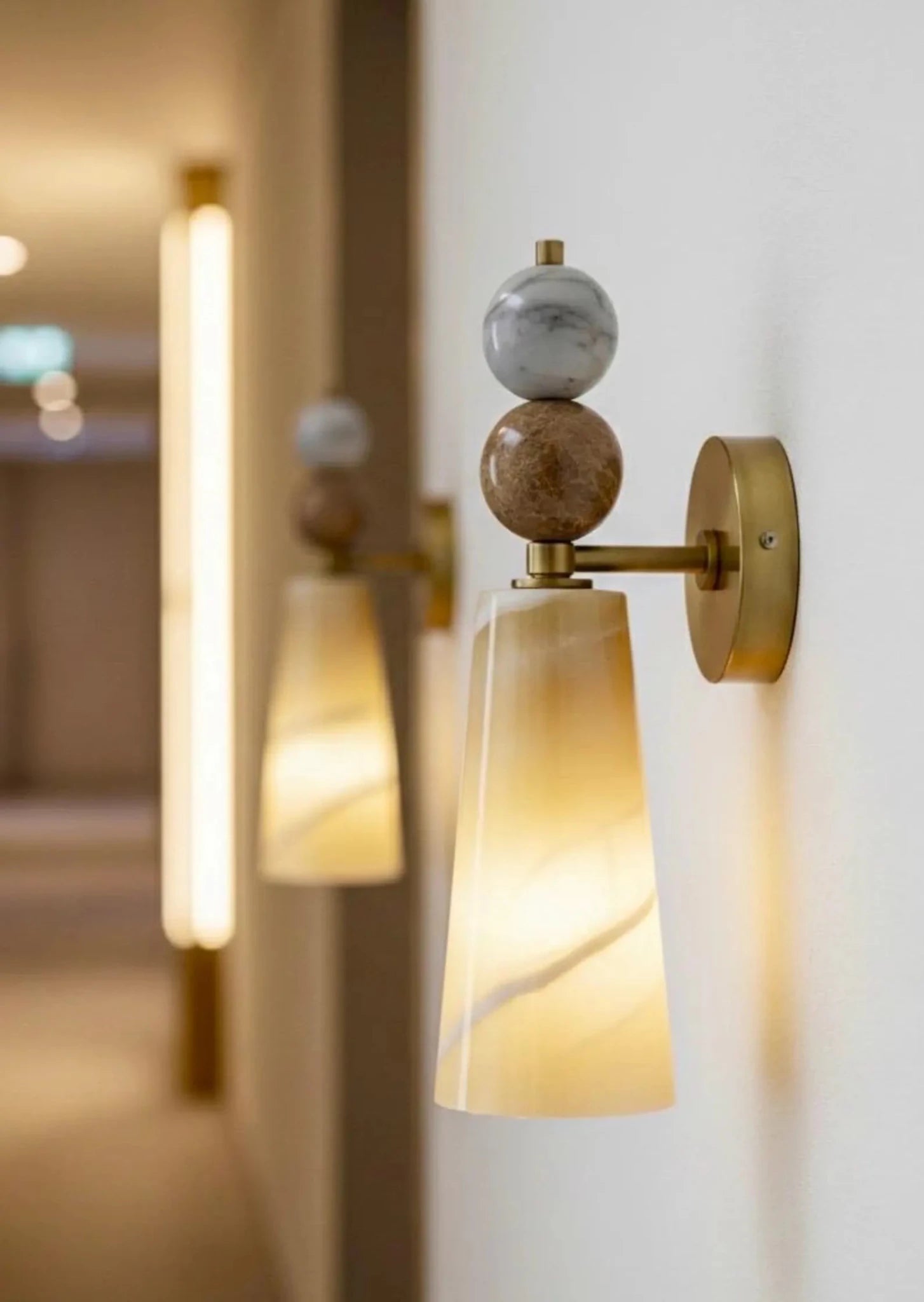 Decorative wall sconce with marble-like finish on a white wall.