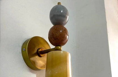 Decorative wall sconce with gold, brown, and gray spherical elements.