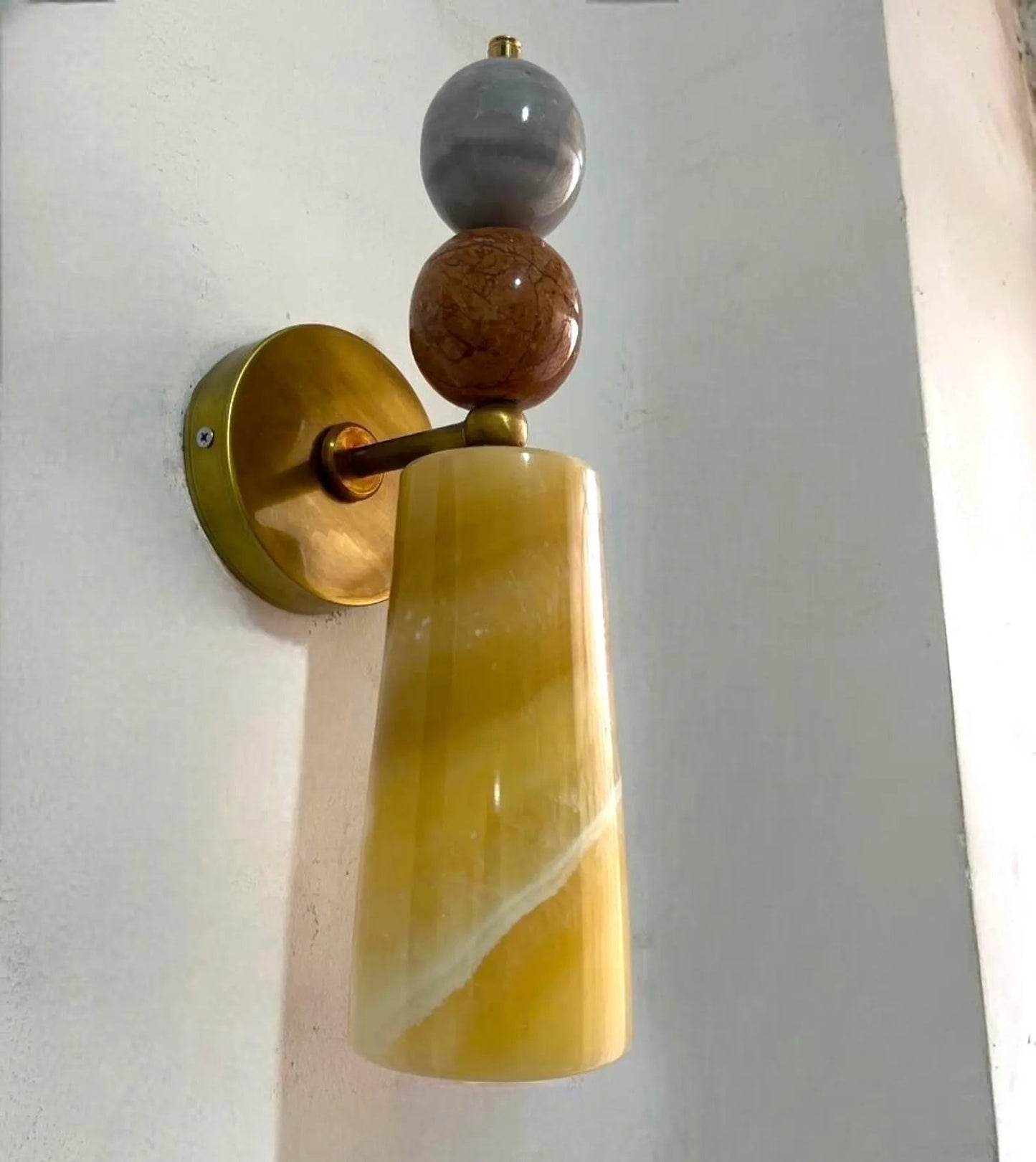 Wall sconce with gold finish and marble-like design