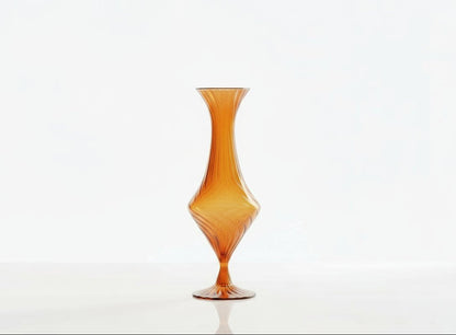 Two glass vases, one orange and one green, with decorative plants on a white background.