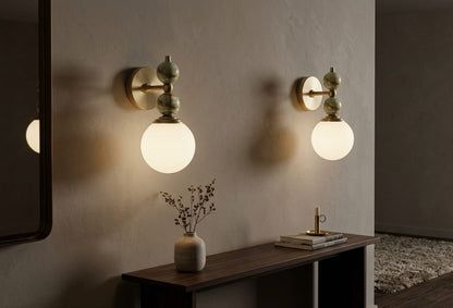 Hand adjusting a wall-mounted light fixture with marble accents on a plain wall.