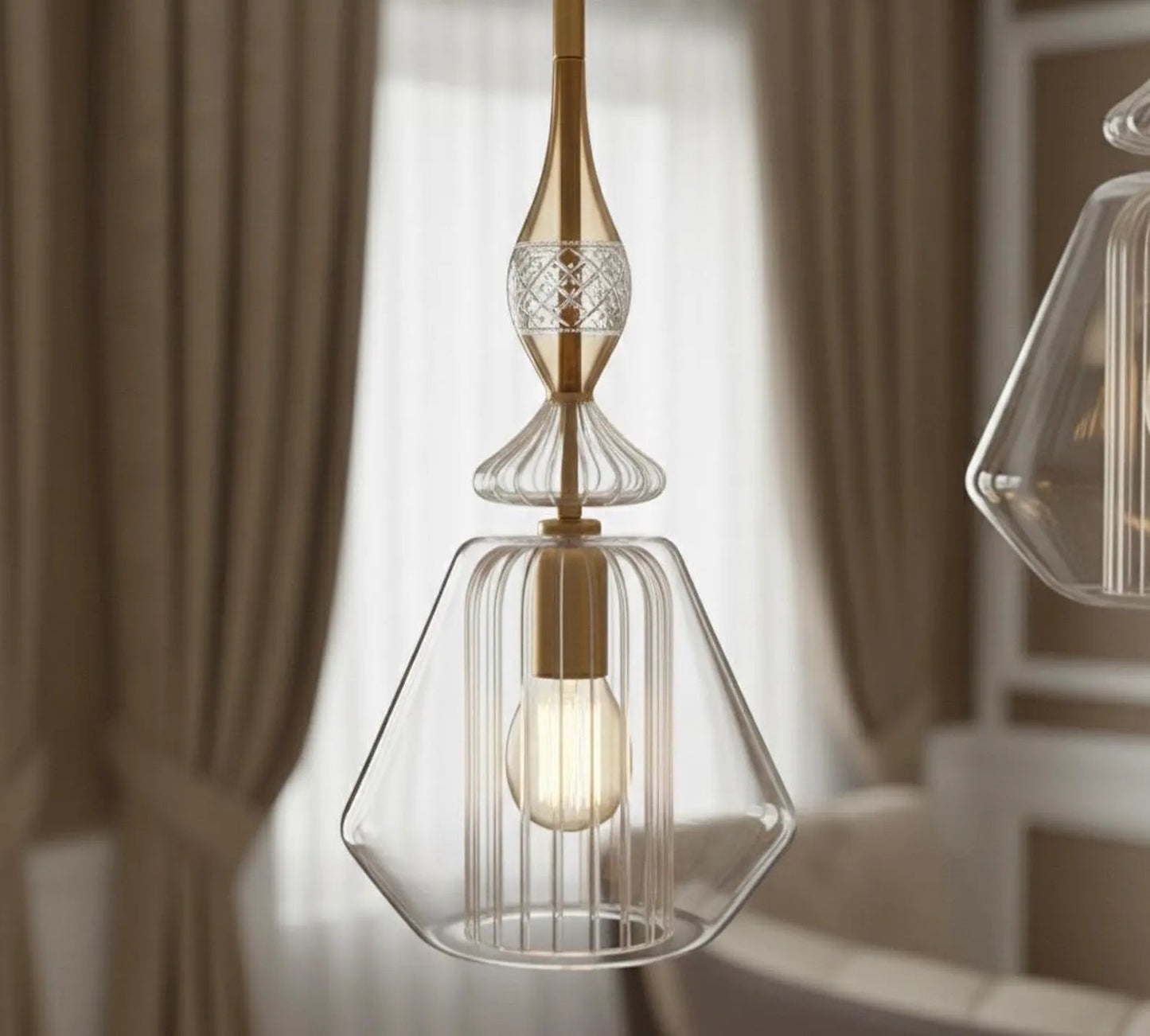 Modern pendant light with clear glass shade and gold accents in a room setting.