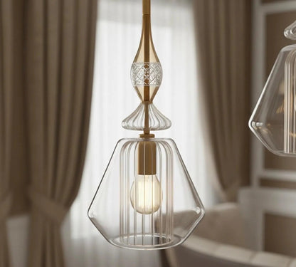Modern pendant light with clear glass shade and gold accents in a room setting.