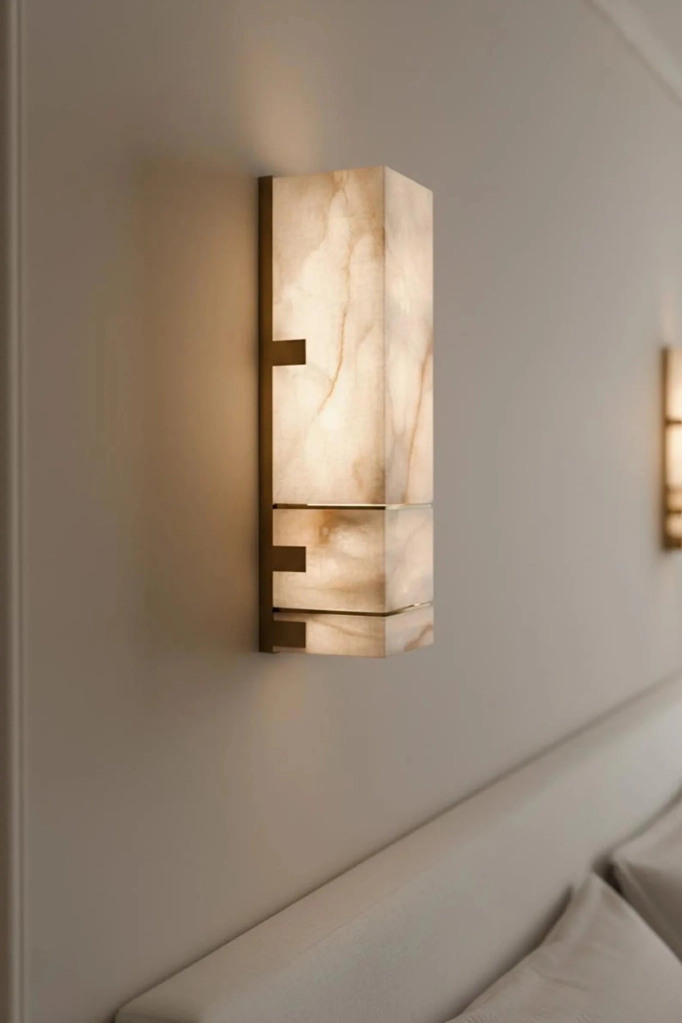 Decorative wall sconce with marble-like finish on a neutral wall.