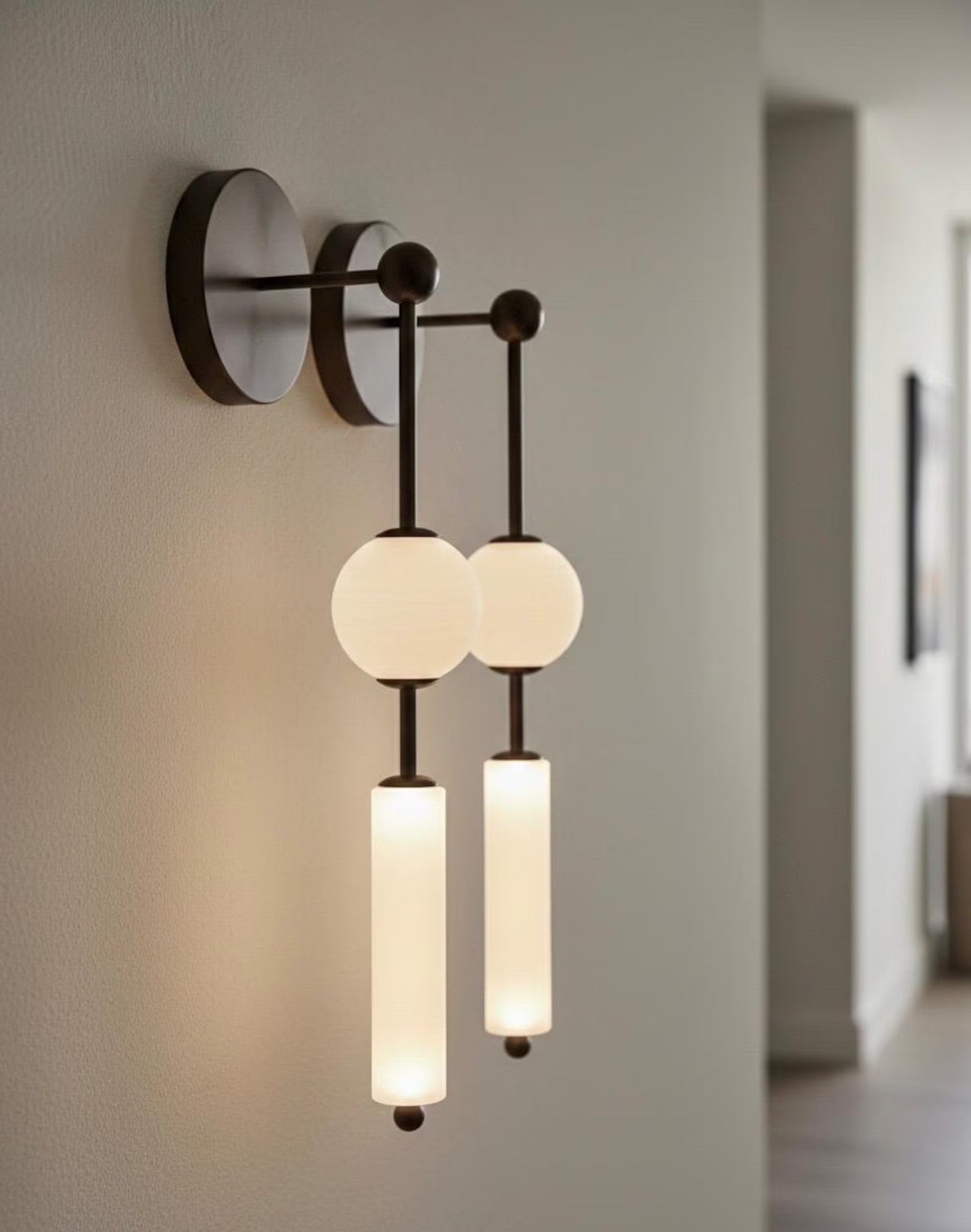 Modern wall sconce with three light bulbs on a neutral wall.