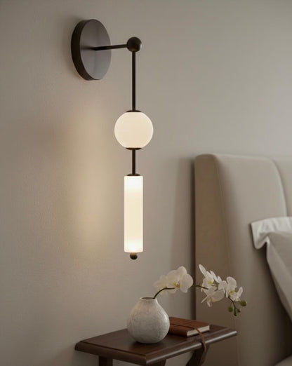 Modern wall lamp with a vase and flowers on a bedside table in a bedroom setting.