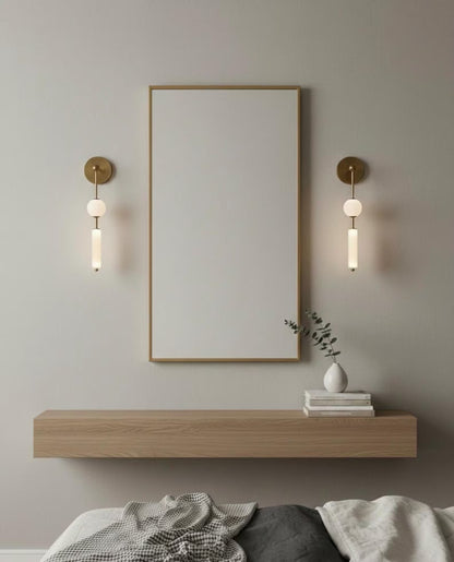 Modern bedroom setup with a large mirror, wall lights, and a wooden shelf.