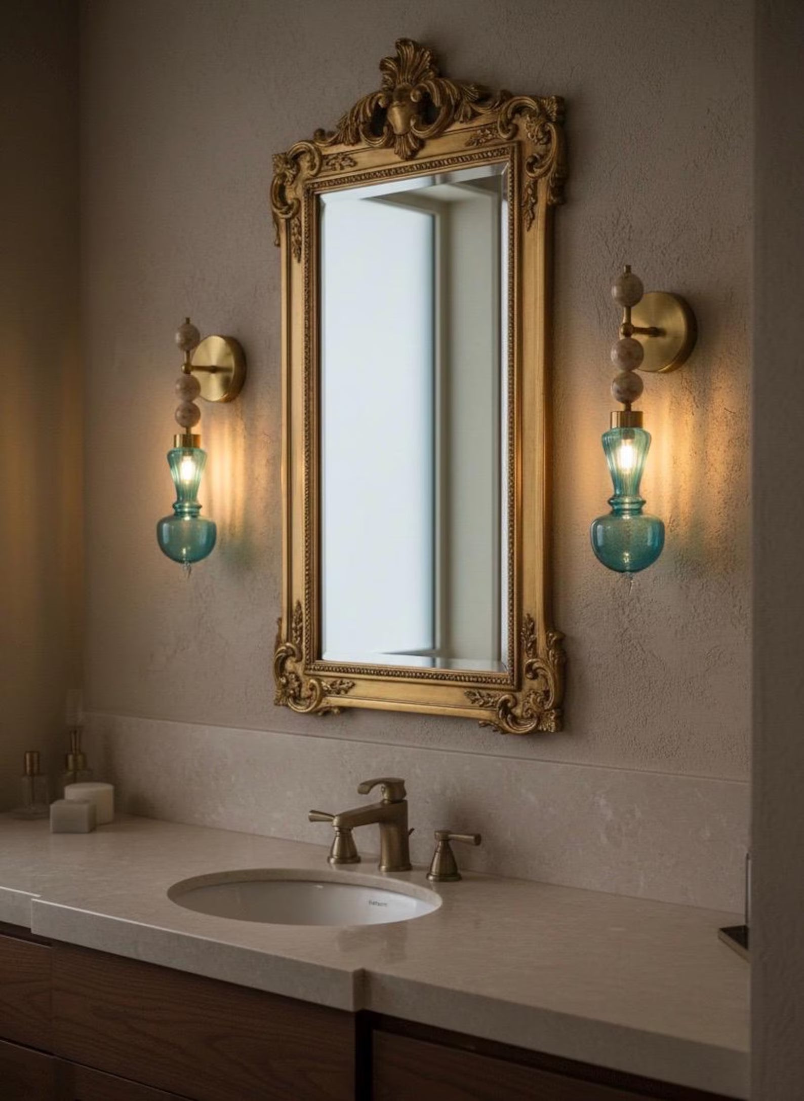 Bathroom vanity with ornate gold mirror and decorative wall lights.